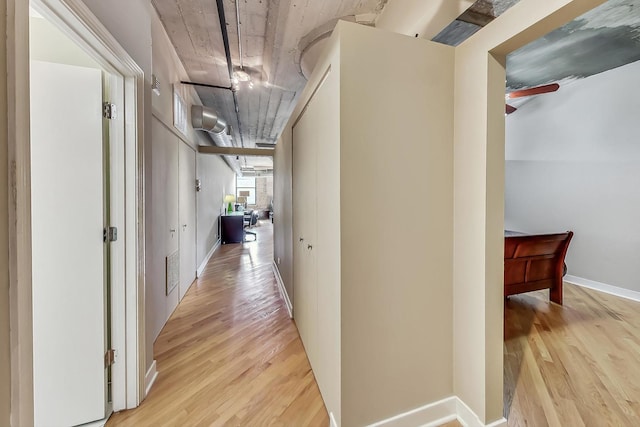 hall with visible vents, baseboards, and wood finished floors