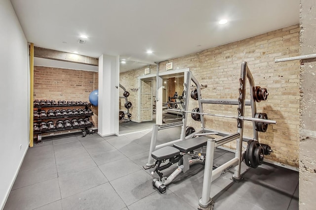 workout room featuring recessed lighting, visible vents, and brick wall