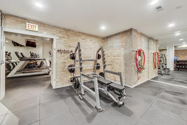 workout area with recessed lighting, visible vents, and brick wall