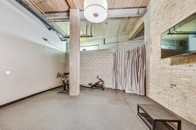 interior space with baseboards and brick wall