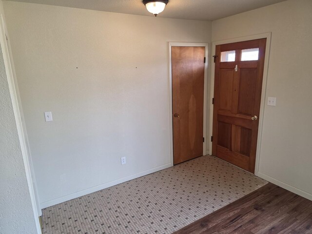 foyer entrance with baseboards and wood finished floors