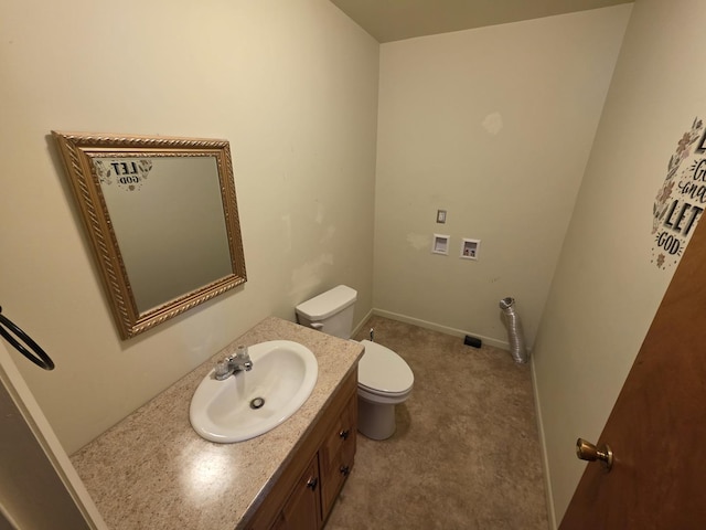 bathroom with baseboards, toilet, and vanity