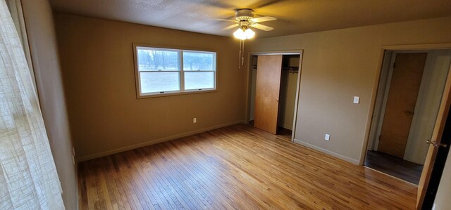 unfurnished bedroom with light wood finished floors, baseboards, a closet, and a ceiling fan