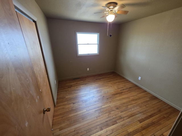 unfurnished bedroom with hardwood / wood-style floors, baseboards, ceiling fan, a closet, and a textured ceiling