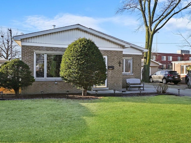 view of front of house featuring brick siding and a front lawn