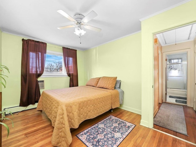 bedroom featuring ornamental molding, a ceiling fan, light wood finished floors, baseboards, and attic access