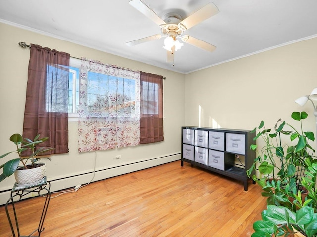 sitting room with crown molding, a baseboard heating unit, a ceiling fan, and wood finished floors