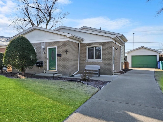 view of front of property with an outbuilding, a front yard, a detached garage, and brick siding