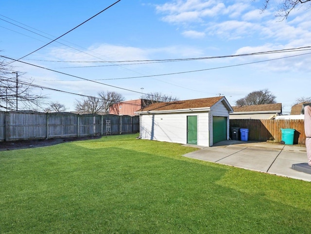 view of yard featuring a garage, an outbuilding, and a fenced backyard