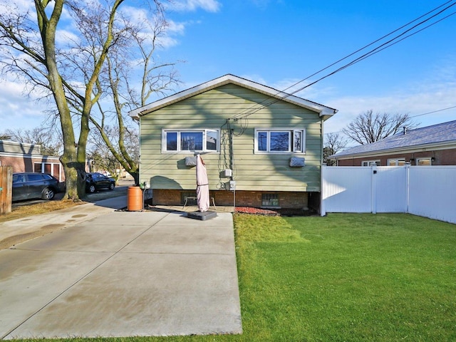 view of front of home with a front yard and fence