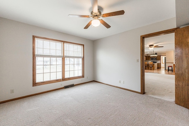 unfurnished room featuring baseboards, light carpet, visible vents, and a ceiling fan