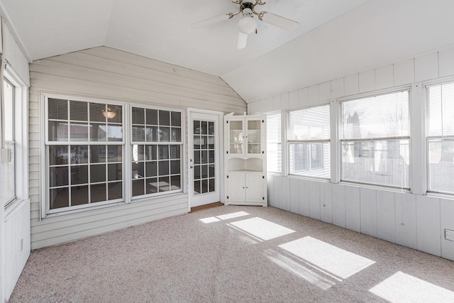 unfurnished sunroom with a healthy amount of sunlight, a ceiling fan, and vaulted ceiling