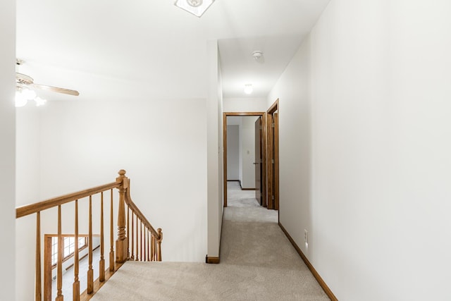 hallway with baseboards, light carpet, an upstairs landing, and a baseboard heating unit