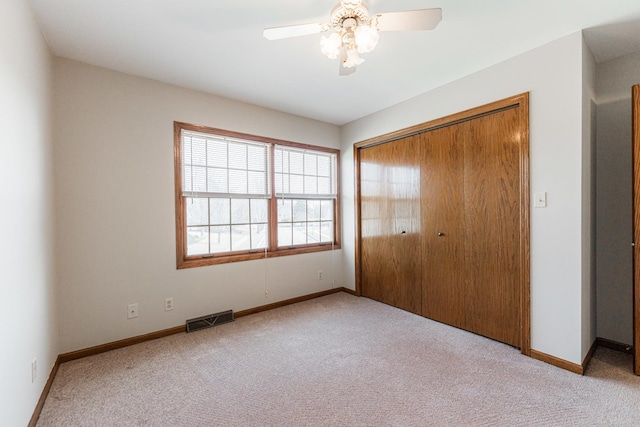 unfurnished bedroom featuring visible vents, baseboards, carpet, and a closet