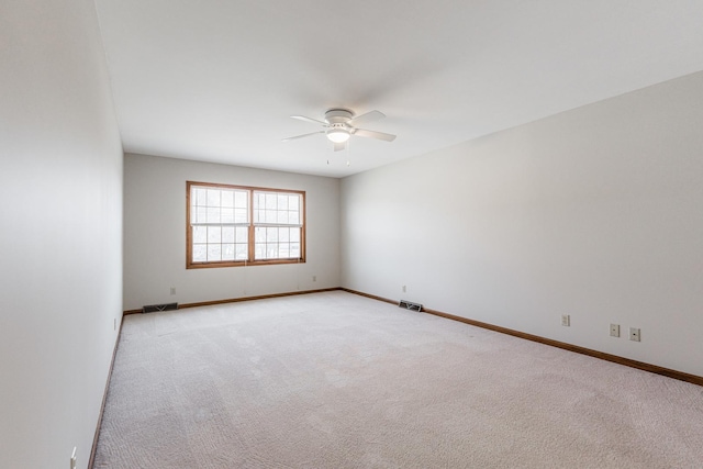 unfurnished room featuring visible vents, light carpet, baseboards, and a ceiling fan