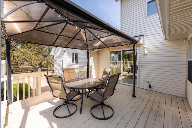 deck with a gazebo and outdoor dining area