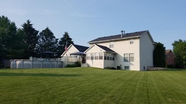 rear view of property with a yard and an outdoor pool