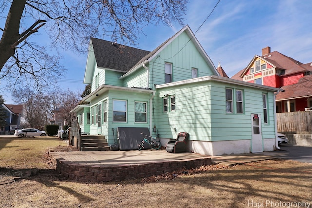 back of house with a patio area, a shingled roof, and fence