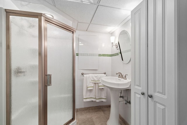 full bathroom featuring tile patterned flooring, a shower stall, and a drop ceiling