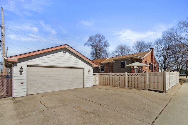 ranch-style house with a detached garage, an outdoor structure, and fence