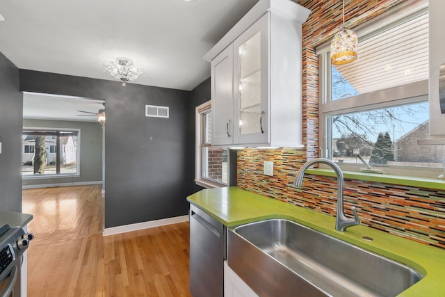 kitchen featuring visible vents, a sink, tasteful backsplash, white cabinets, and dishwasher