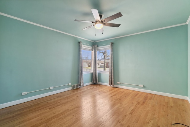 unfurnished room with visible vents, a ceiling fan, wood finished floors, crown molding, and baseboards