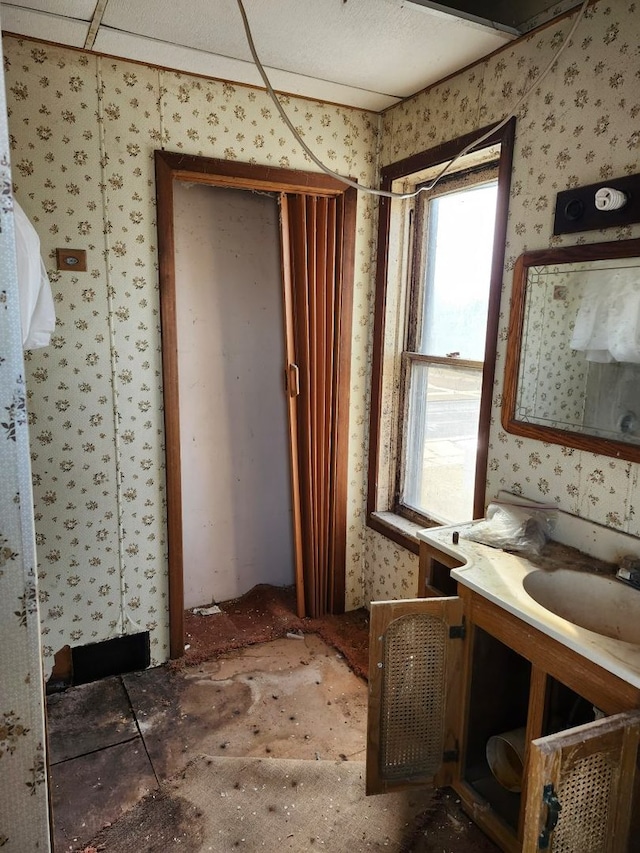 bathroom featuring wallpapered walls and vanity