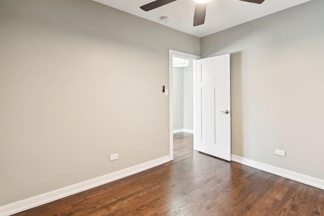 unfurnished room with a ceiling fan, dark wood-style floors, and baseboards