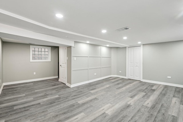 below grade area featuring recessed lighting, wood finished floors, visible vents, and baseboards