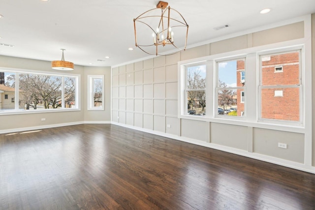 unfurnished room with visible vents, recessed lighting, an inviting chandelier, and wood finished floors