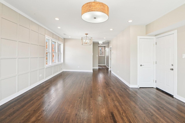 spare room featuring recessed lighting, a chandelier, baseboards, and dark wood-style floors