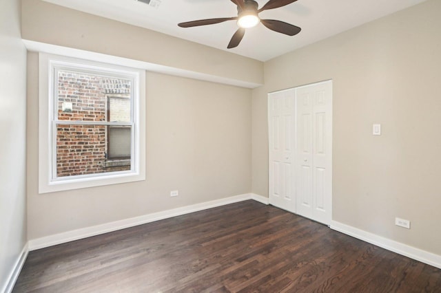 unfurnished bedroom featuring a closet, baseboards, and dark wood finished floors