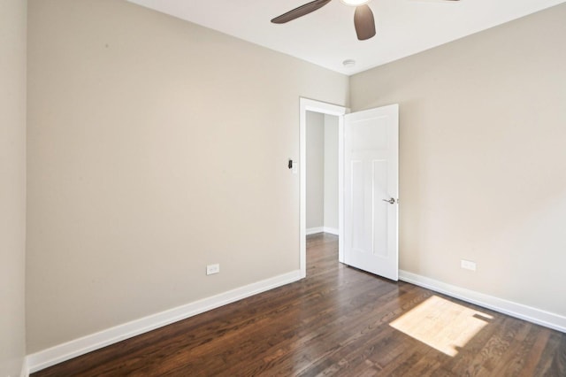 unfurnished room with baseboards, a ceiling fan, and dark wood-style flooring