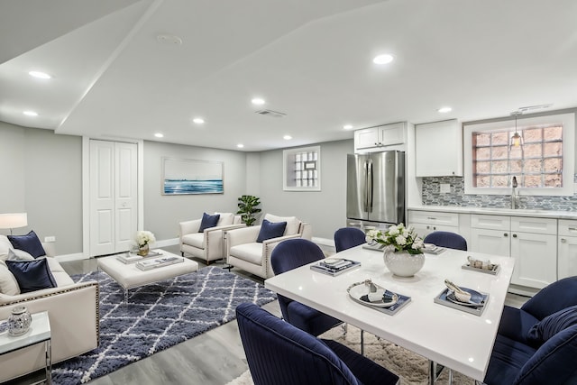 living room featuring recessed lighting, wood finished floors, visible vents, and baseboards