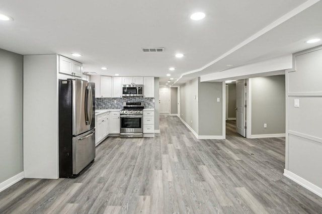 kitchen featuring white cabinetry, light wood-style floors, tasteful backsplash, and appliances with stainless steel finishes