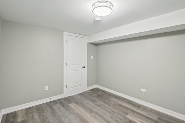 finished below grade area featuring baseboards and wood finished floors