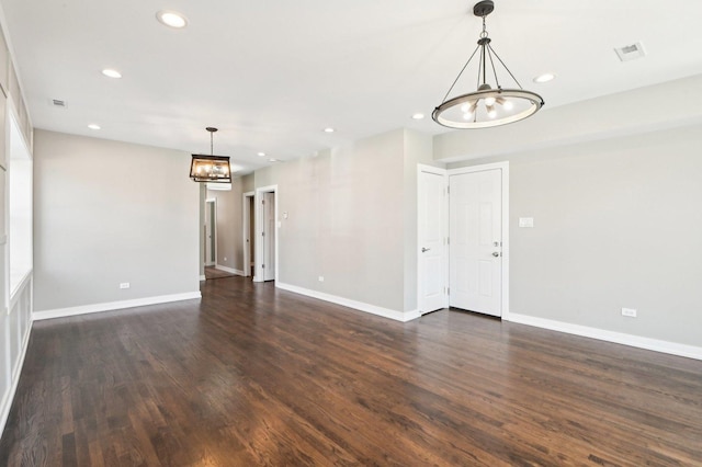 spare room featuring visible vents, baseboards, recessed lighting, dark wood-style floors, and a notable chandelier