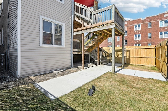 rear view of house featuring a patio area, a lawn, stairs, and fence