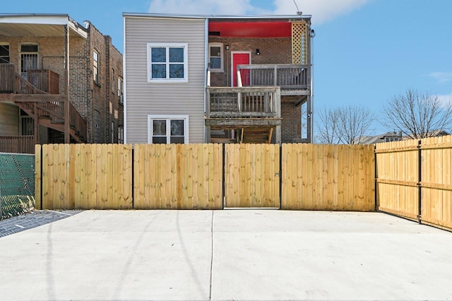 rear view of house with a balcony and fence