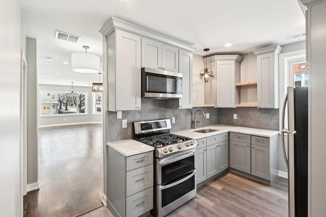 kitchen with visible vents, appliances with stainless steel finishes, gray cabinetry, and a sink