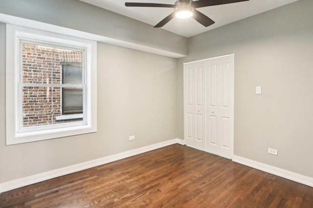 unfurnished bedroom featuring a closet, a ceiling fan, baseboards, and wood finished floors