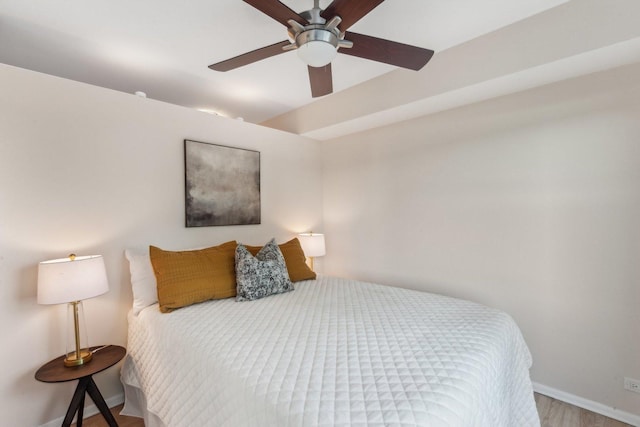 bedroom featuring wood finished floors, baseboards, and ceiling fan