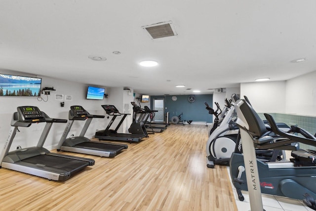 gym with visible vents, baseboards, and wood finished floors