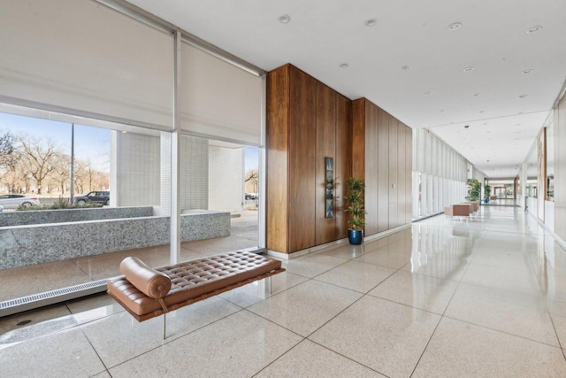 hallway featuring light speckled floor and a towering ceiling