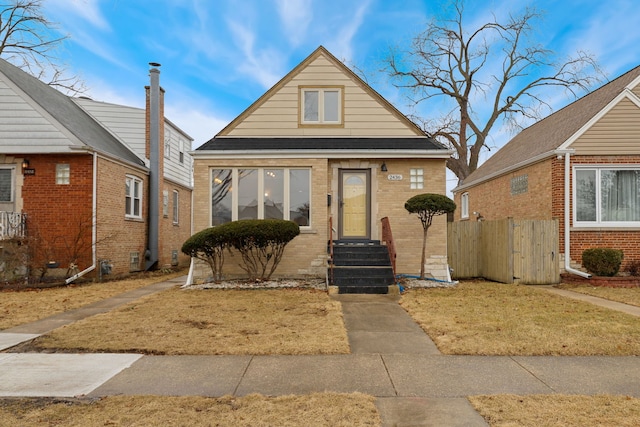 bungalow-style house featuring brick siding and entry steps