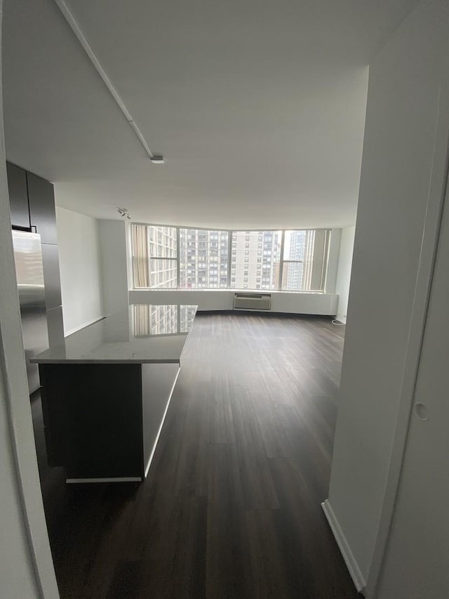 corridor with dark wood-style flooring and a wall unit AC