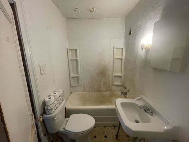 full bathroom featuring toilet, shower / bath combination, a textured wall, and a sink