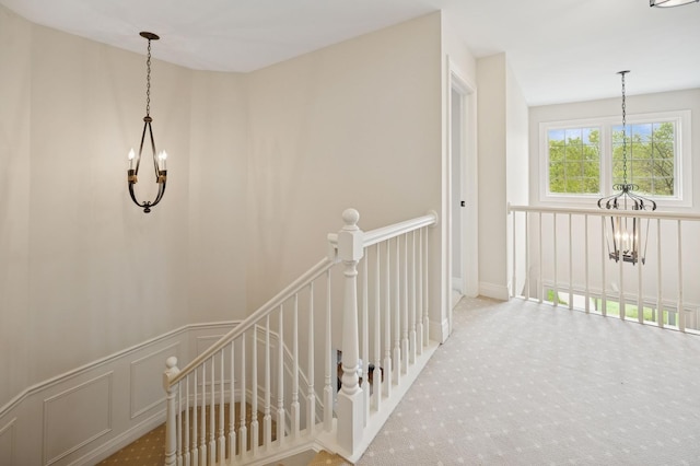 staircase featuring a chandelier and carpet floors