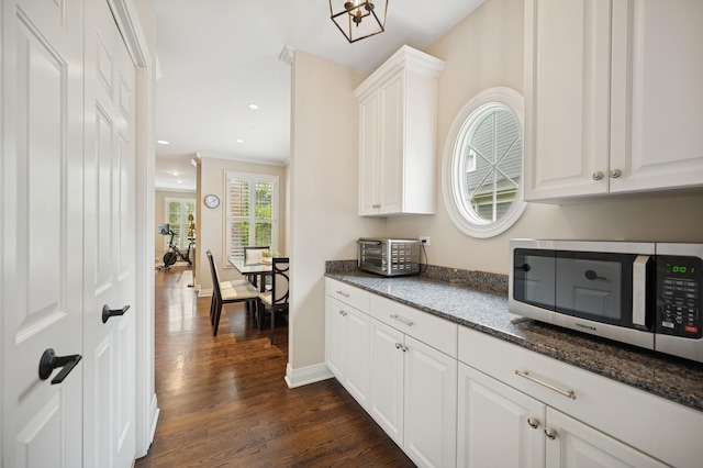 bar featuring stainless steel microwave, recessed lighting, a toaster, dark wood-style flooring, and baseboards