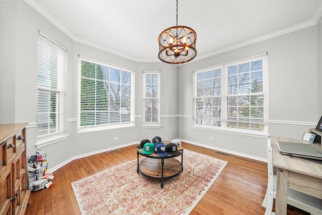 sitting room with an inviting chandelier, crown molding, wood finished floors, and baseboards